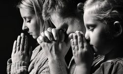 Praying family. Man, woman and child.