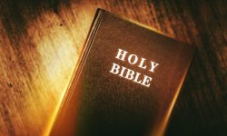 Holy Bible in Dark Browny Vintage Color Grading. Glowing Light Holy Bible